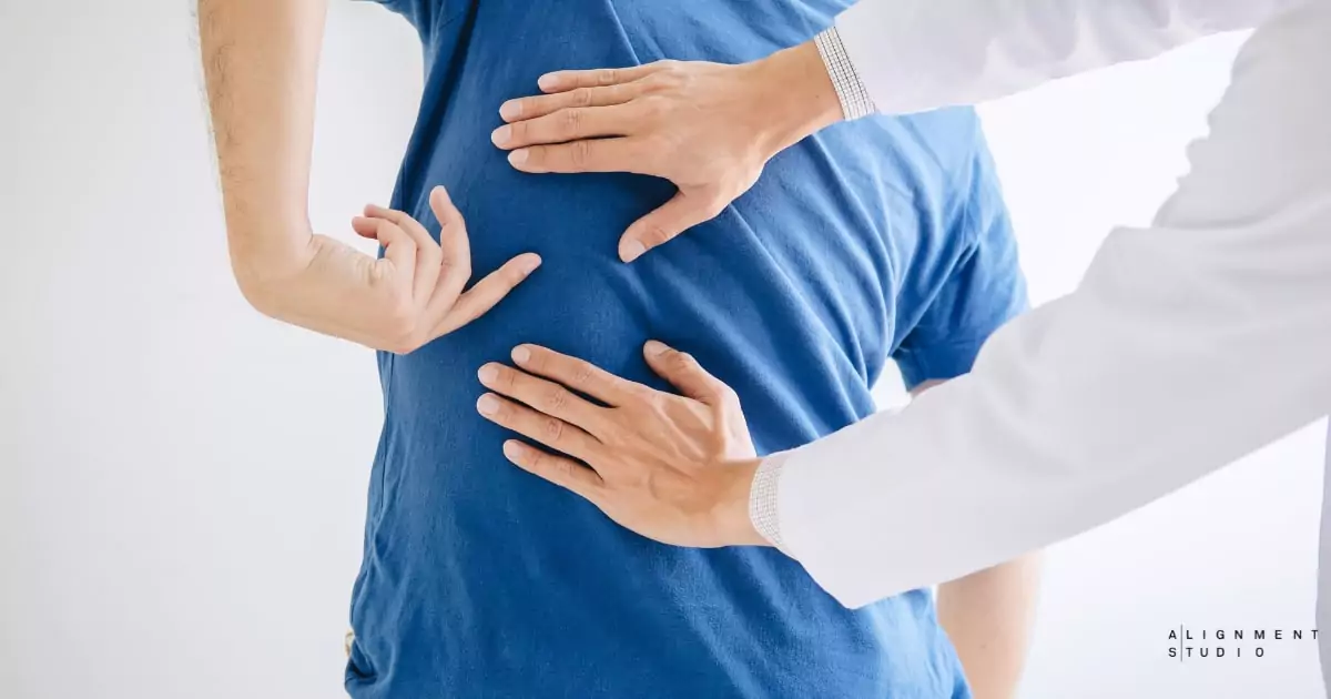 A physical therapist assisting a patient with exercises for disc herniation treatment physiotherapy.